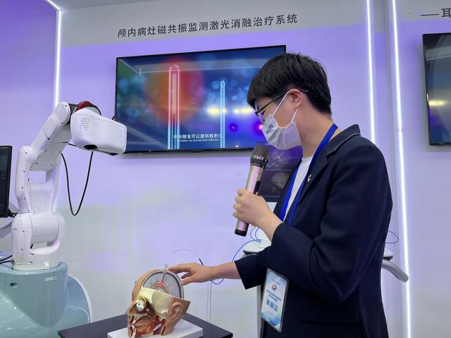 工作人員向大家介紹顱內(nei) 病灶磁共振監測激光消融治療係統。宋婧 攝